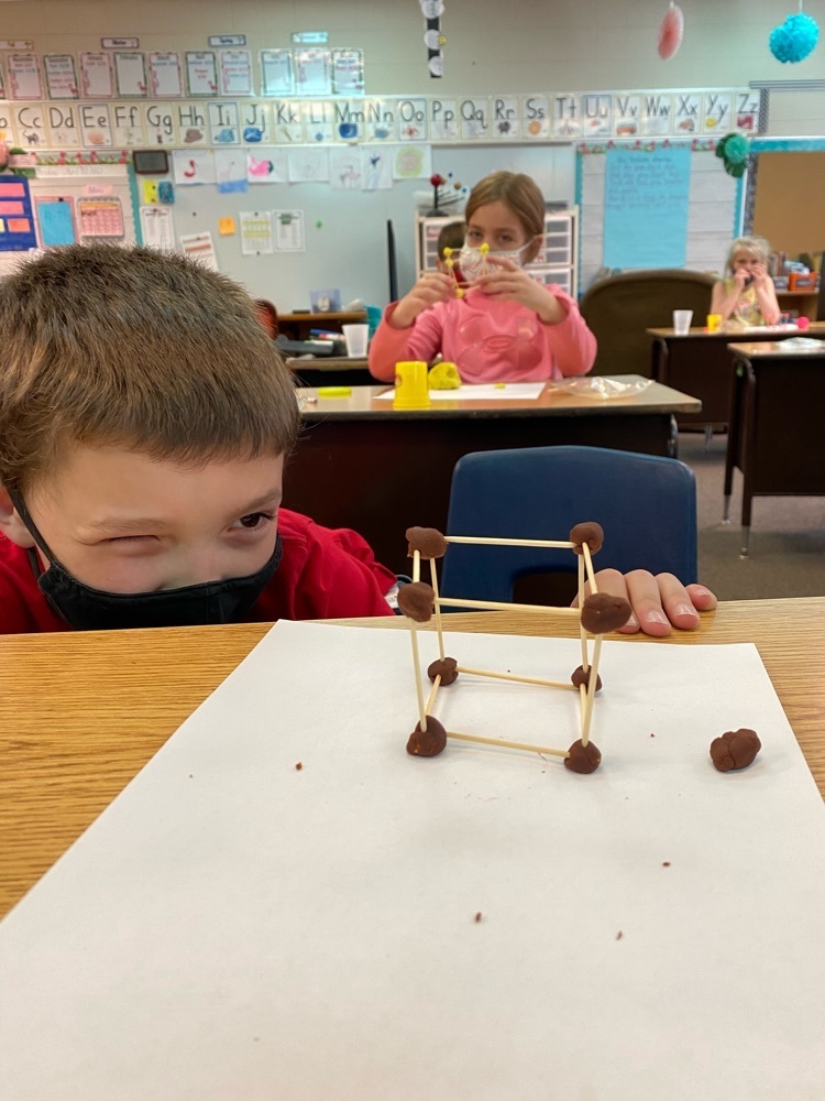 A student crouches to see his cube from a different perspective.