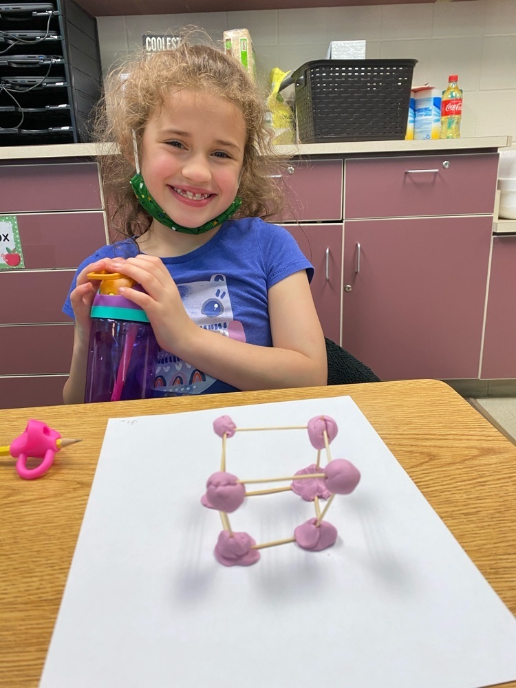 A student smiles happily at her cube.